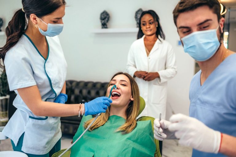 Woman patient in dental clinic being examined by a male dentist